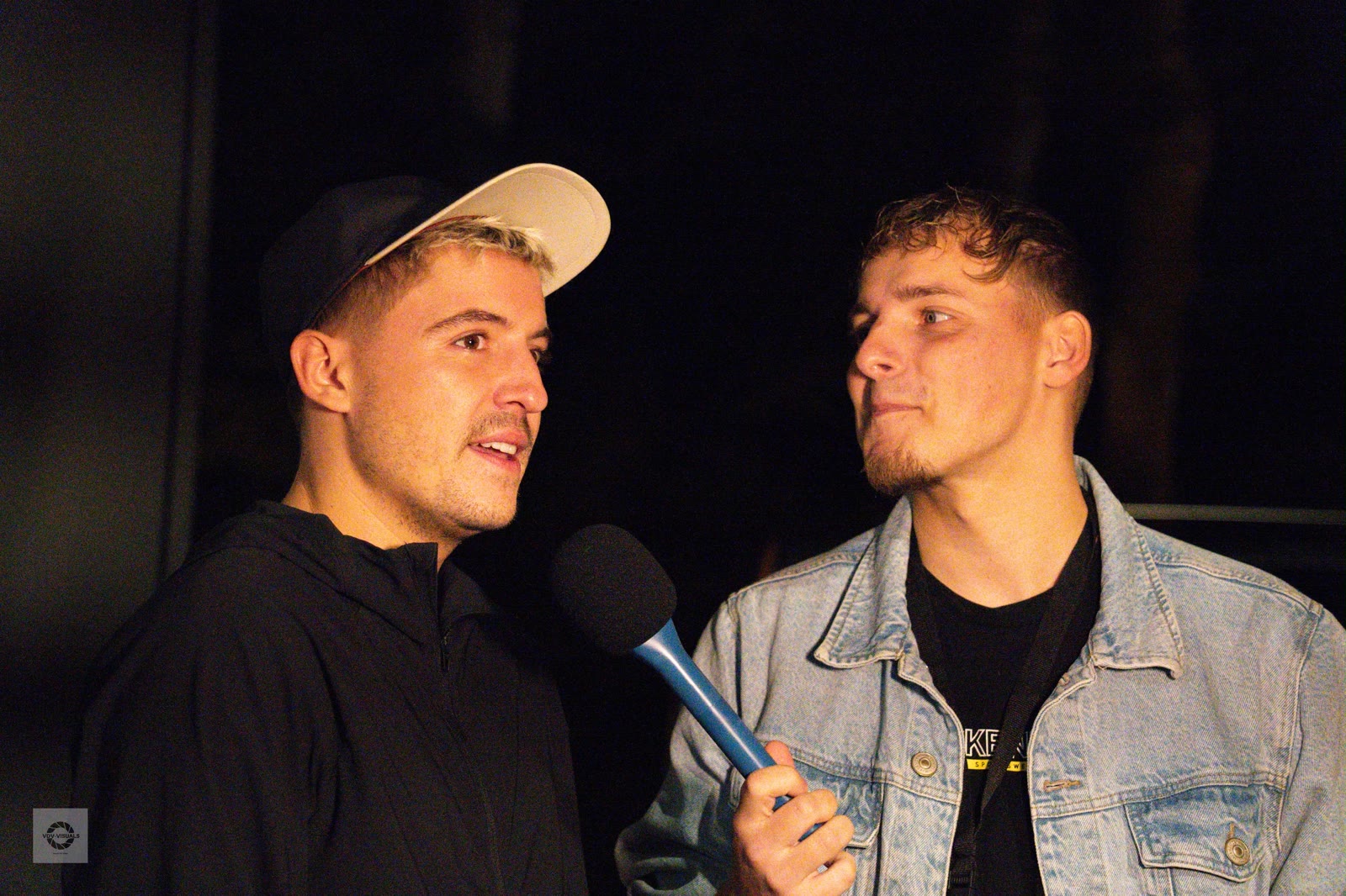 Interviewmoment op festival — microfoon en gesprek in beeld