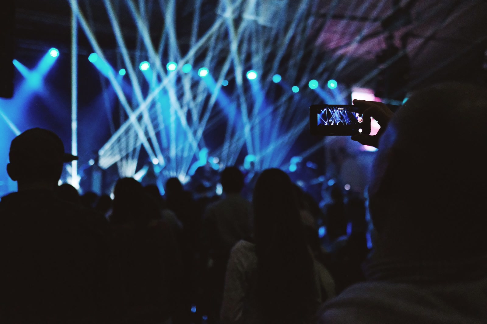 Handen filmen een festivalpodium met een smartphone — short-form content van Spits Media